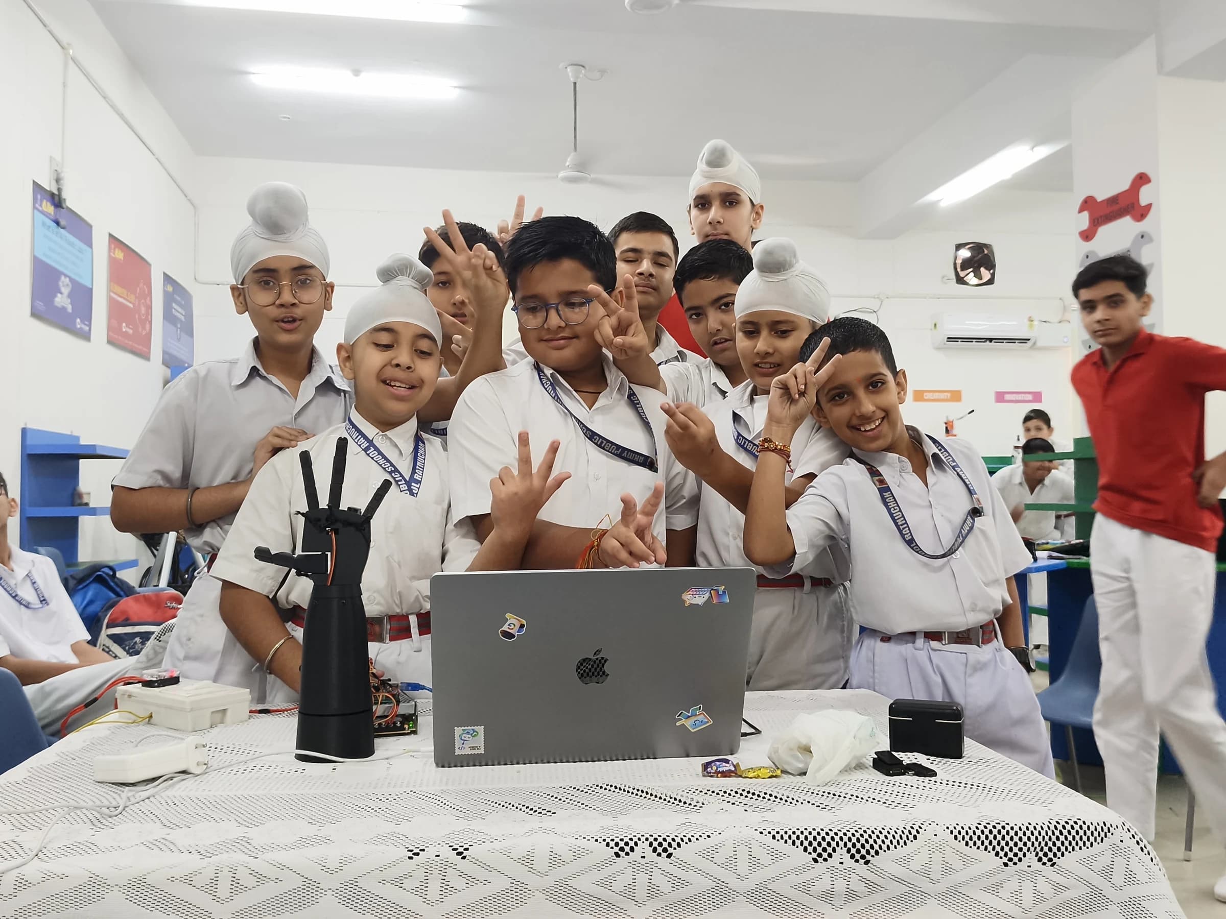 Army Public School Ratnuchak students exploring a gesture-controlled robotic hand during a practical AI and electronics workshop in Jammu.